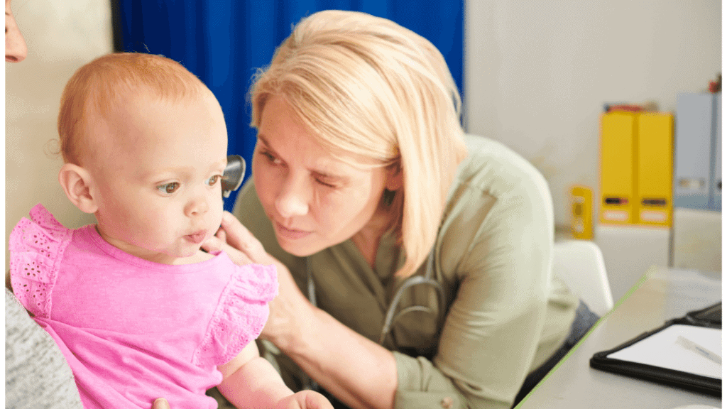 Doctor checking baby's ears