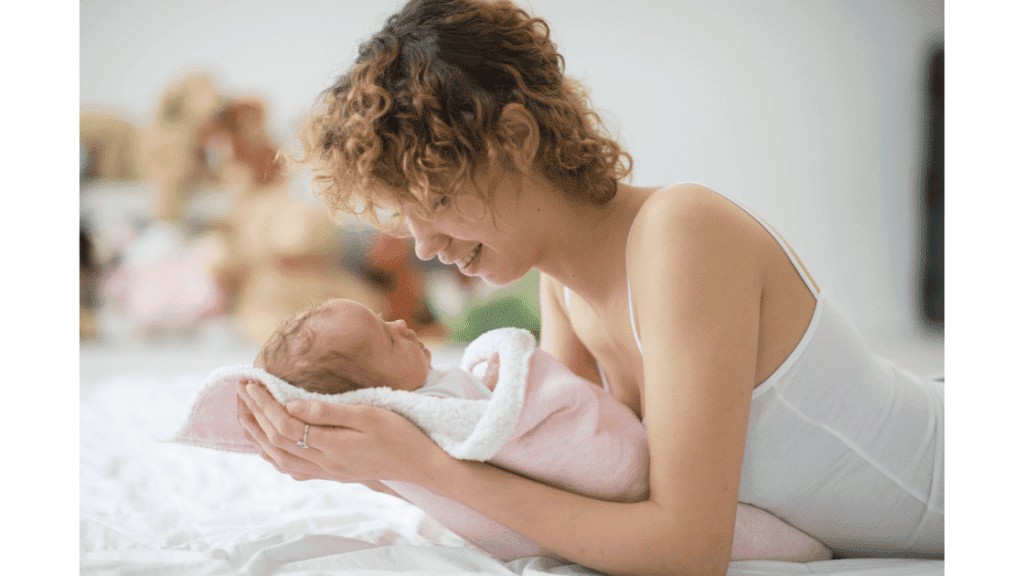 mother holding swaddled baby